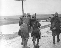Avance inicial. La infantería italiana en la meseta de Trijueque. Dos soldados ayudan a un herido; un tercer soldado transporta un trípode de ametralladora. Fuente: Bundesarchiv