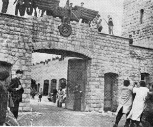 Españoles (abajo con gabardinas) derriban el águila en la puerta del campo de concentración de Mauthausen.